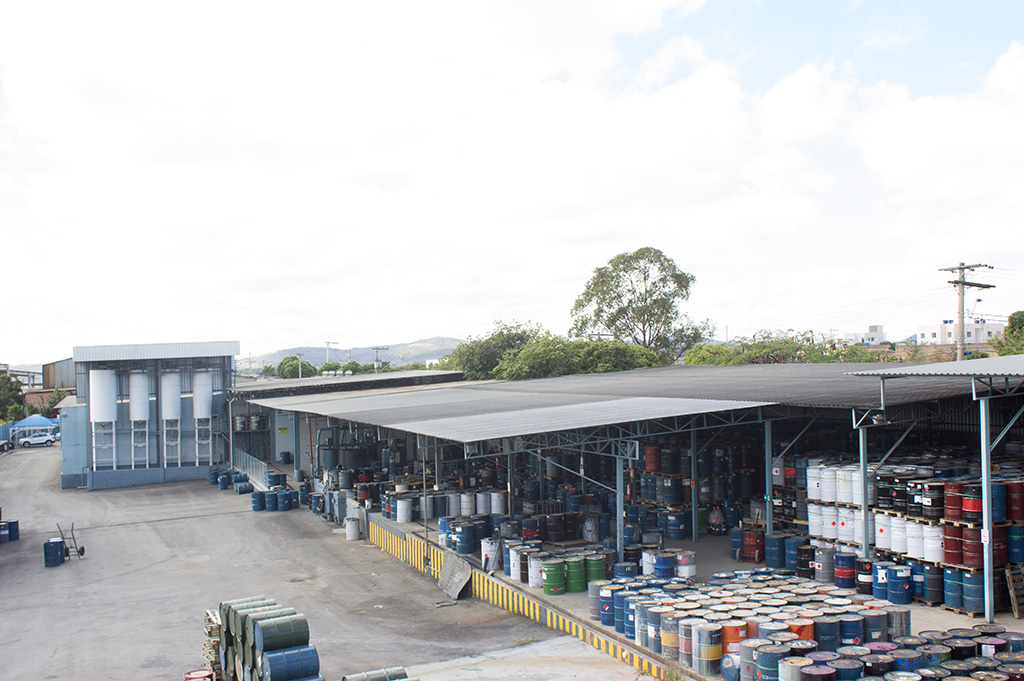 Pátio da fábrica ColorMax em Divinópolis/MG com tambores de solvente e tanques de armazenagem